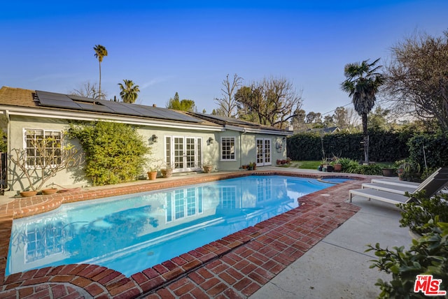 view of swimming pool featuring a patio and french doors