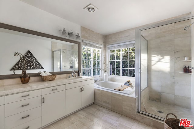 bathroom with tile patterned flooring, vanity, and separate shower and tub