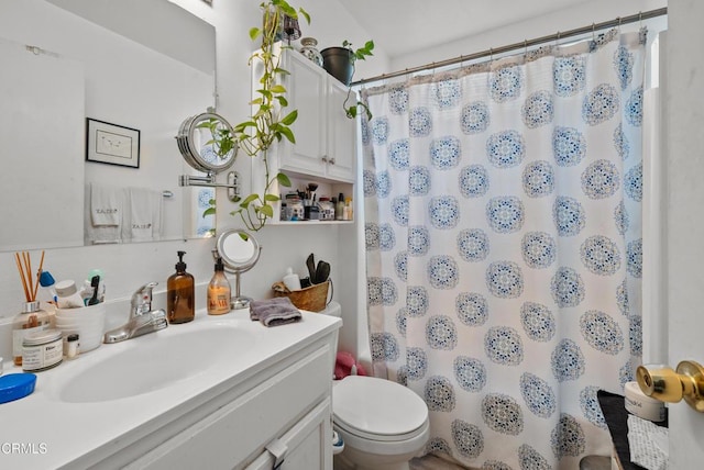 bathroom with vanity, curtained shower, and toilet