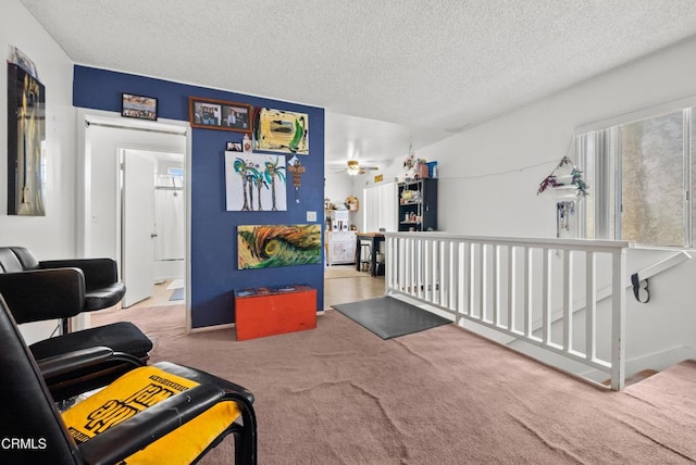 interior space featuring ceiling fan, a textured ceiling, and carpet