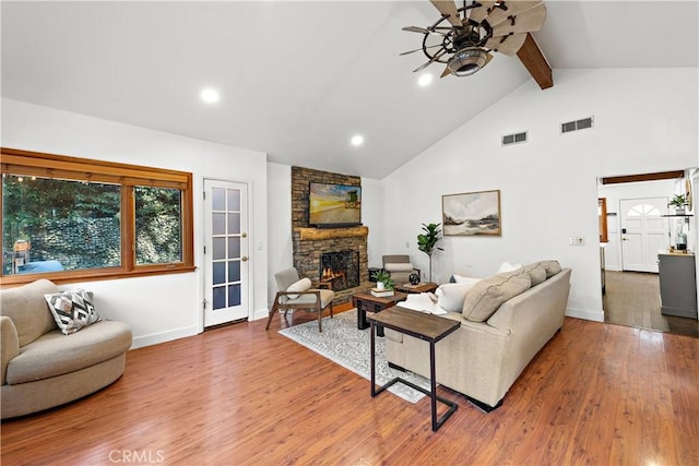 living room with high vaulted ceiling, a fireplace, hardwood / wood-style floors, and beam ceiling