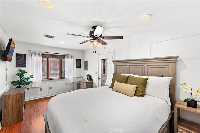 bedroom featuring ceiling fan, electric panel, and dark hardwood / wood-style flooring