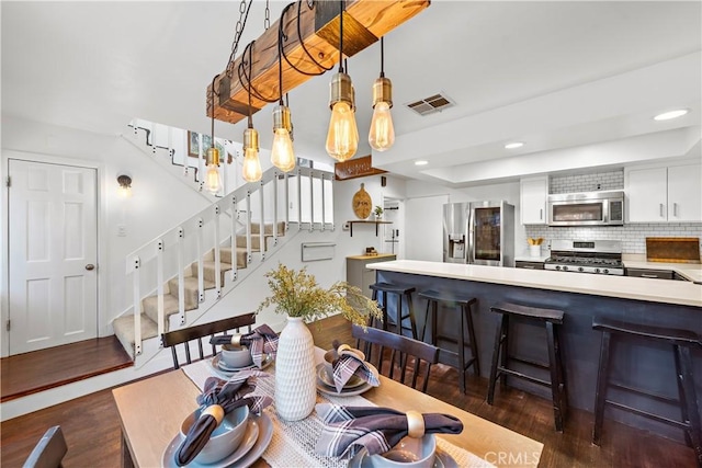 dining area featuring dark hardwood / wood-style floors and a raised ceiling