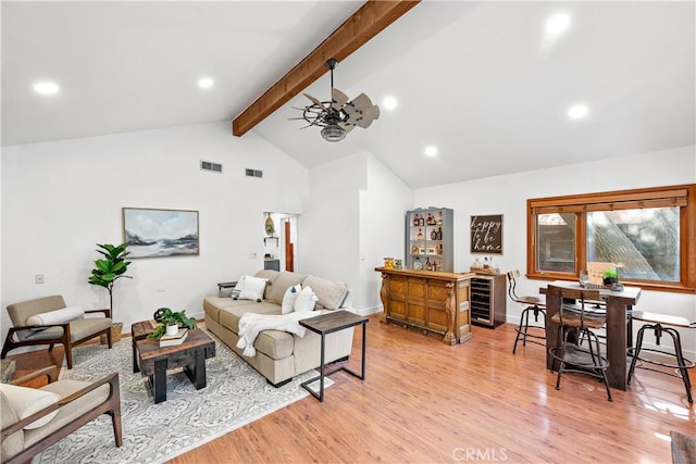 living room featuring wine cooler, bar area, light wood-type flooring, ceiling fan, and beam ceiling