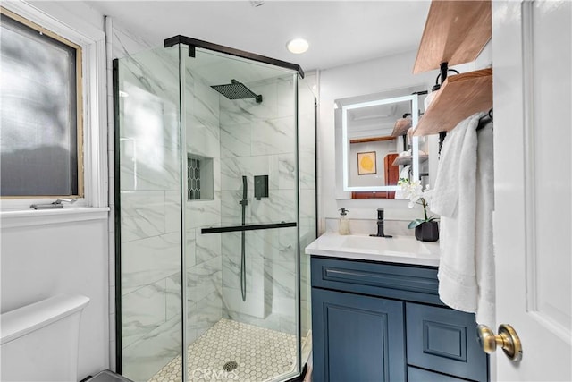 bathroom featuring vanity, toilet, and walk in shower