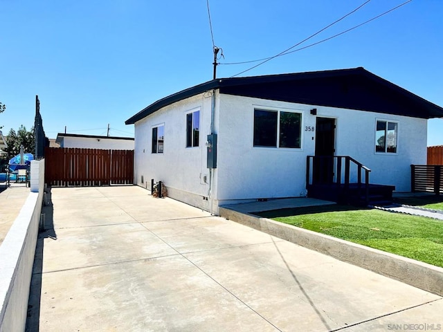 view of front of home featuring a front lawn and a patio area