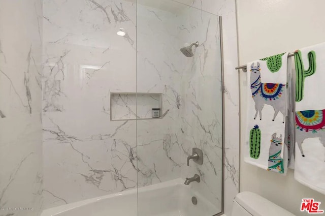 bathroom with toilet and tiled shower / bath combo