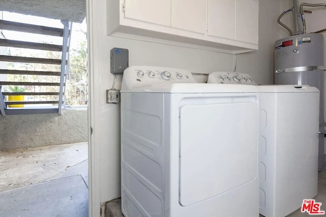 washroom with cabinets, washing machine and clothes dryer, and water heater