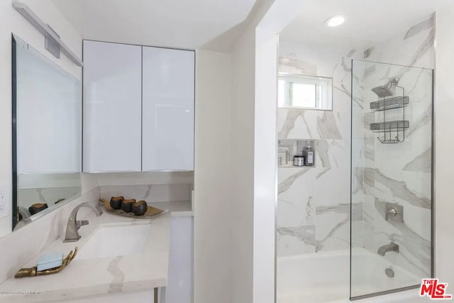 bathroom with sink and shower / bath combination with glass door