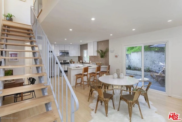 dining room with sink and light wood-type flooring