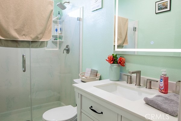 bathroom with vanity, an enclosed shower, and toilet