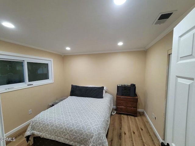 bedroom featuring crown molding and light wood-type flooring