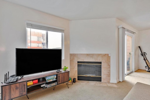 living room with a tiled fireplace and carpet floors