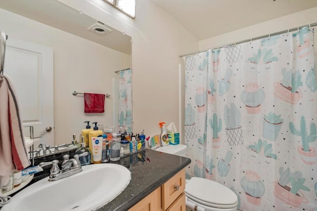 bathroom featuring vanity, curtained shower, and toilet