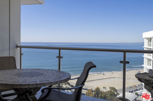 balcony featuring a water view and a view of the beach