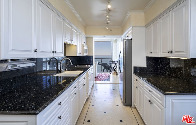 kitchen featuring sink, crown molding, stainless steel fridge, and white cabinets