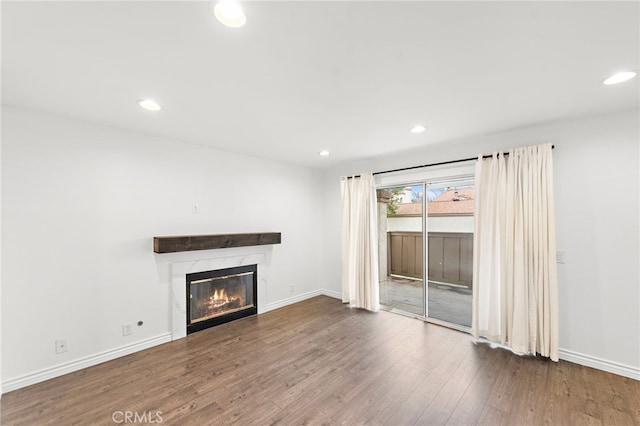 unfurnished living room featuring a high end fireplace and hardwood / wood-style floors