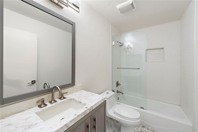 full bathroom featuring tiled shower / bath, vanity, and toilet