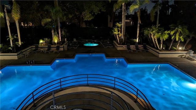 pool at twilight with a patio area