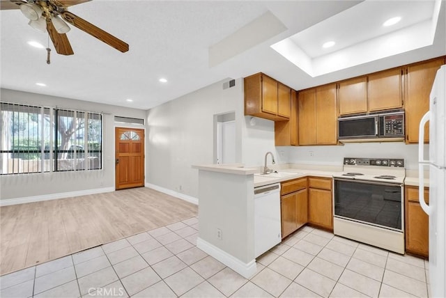 kitchen featuring sink, white appliances, light tile patterned floors, ceiling fan, and kitchen peninsula