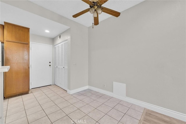 tiled empty room featuring ceiling fan