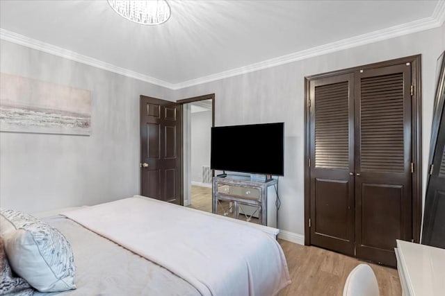 bedroom featuring crown molding, light hardwood / wood-style floors, and a closet