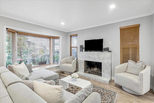 living room featuring crown molding, a high end fireplace, and light hardwood / wood-style floors