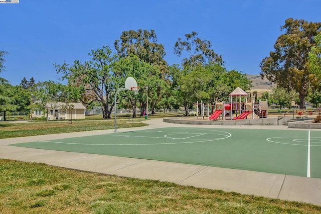 view of basketball court featuring a yard and a playground