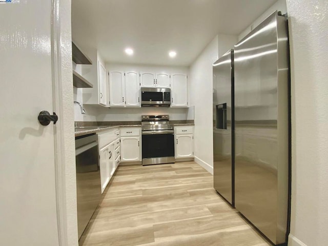 kitchen featuring white cabinetry, appliances with stainless steel finishes, sink, and light hardwood / wood-style flooring