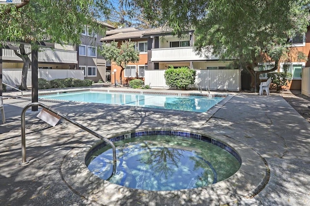 view of swimming pool featuring a hot tub