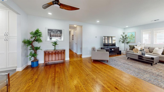 living room featuring light hardwood / wood-style floors and ceiling fan