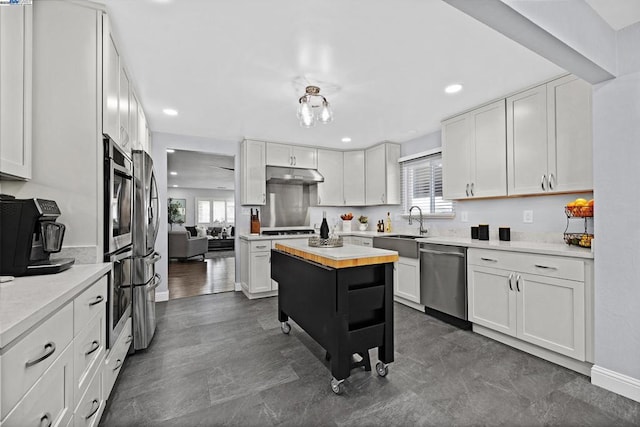 kitchen featuring white cabinetry, a kitchen island, butcher block counters, and appliances with stainless steel finishes