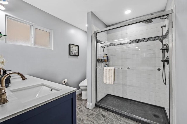 bathroom with vanity, toilet, and a shower with shower door