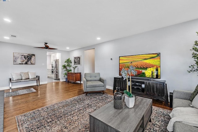 living room with wood-type flooring and ceiling fan