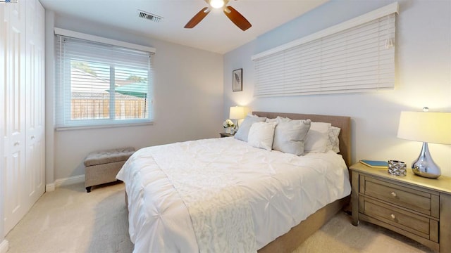 bedroom featuring light carpet, a closet, and ceiling fan