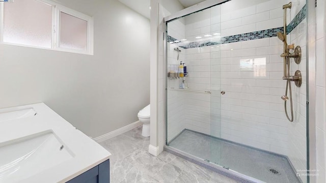 bathroom featuring vanity, toilet, and a shower with door