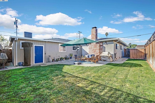 back of property with a yard and a patio area