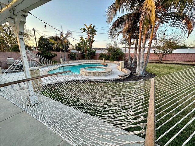 view of pool featuring an in ground hot tub