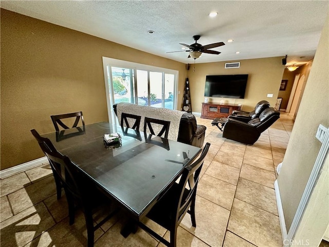 tiled dining space with ceiling fan and a textured ceiling