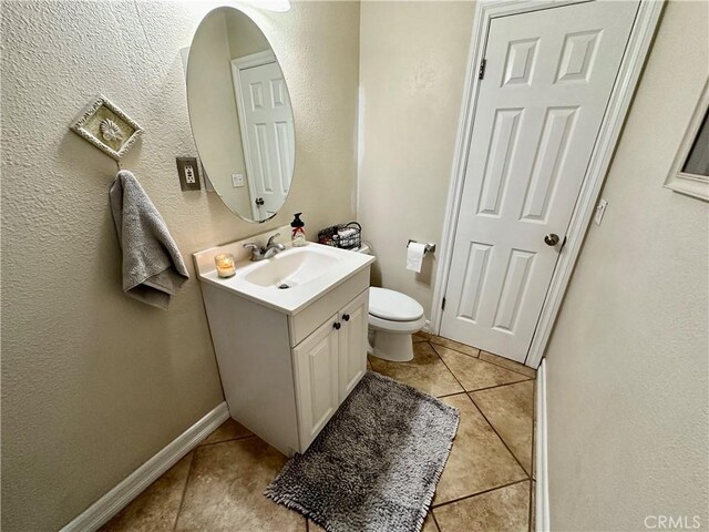 bathroom with tile patterned flooring, vanity, and toilet