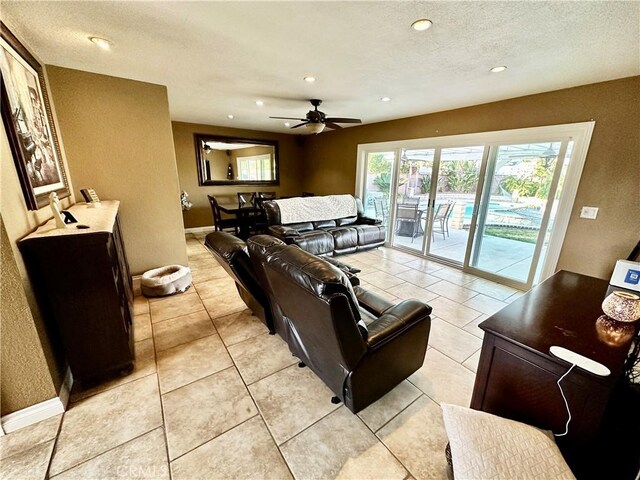 tiled living room featuring ceiling fan and a textured ceiling