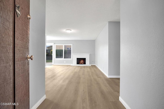 unfurnished living room with light wood-type flooring and a fireplace