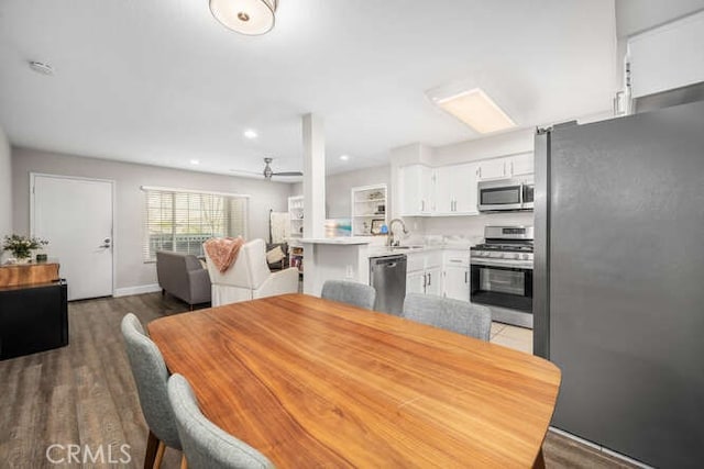 dining area featuring hardwood / wood-style flooring, sink, and ceiling fan