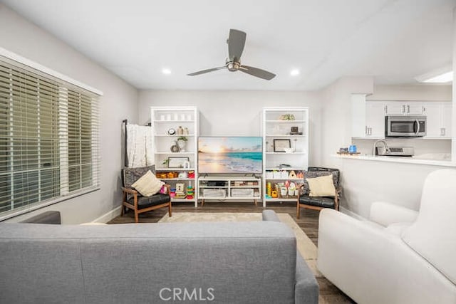 living room featuring ceiling fan and hardwood / wood-style floors