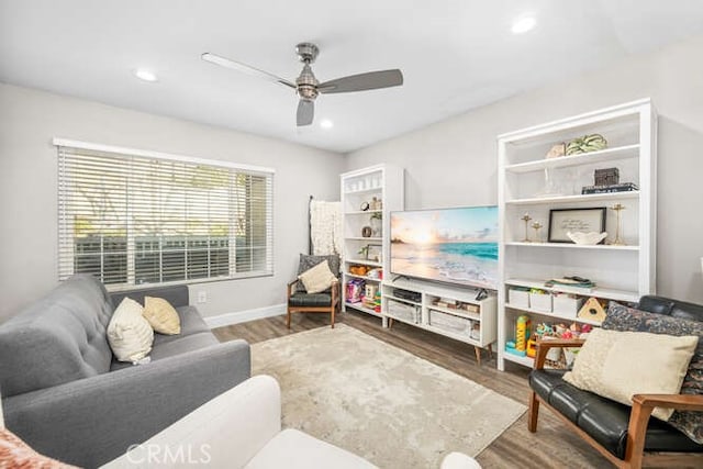 sitting room with baseboards, wood finished floors, a ceiling fan, and recessed lighting