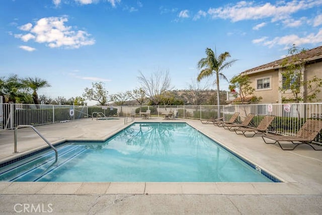 pool with a patio and fence