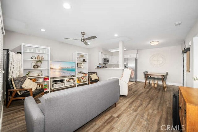 living room featuring wood-type flooring and ceiling fan