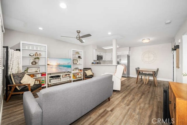 living room featuring recessed lighting, ceiling fan, baseboards, and wood finished floors