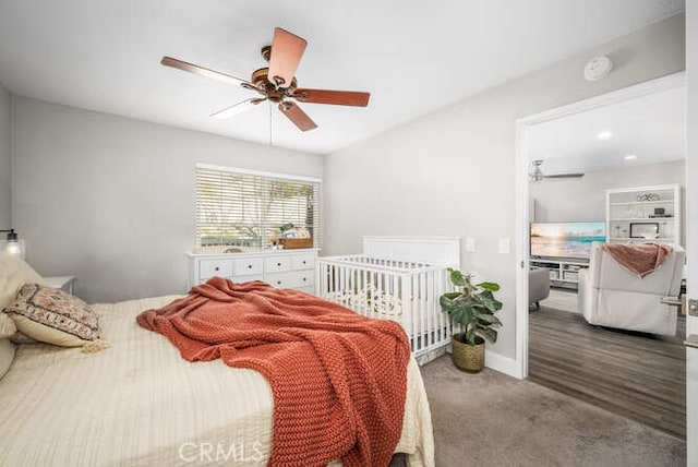 carpeted bedroom with ceiling fan and baseboards