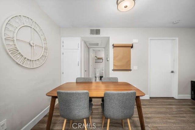 dining area featuring dark wood-style flooring, visible vents, and baseboards